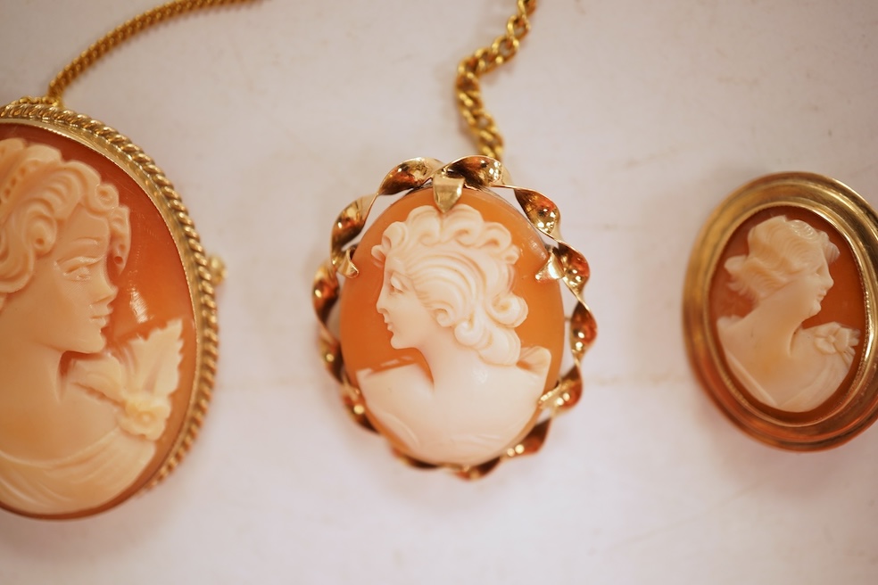 A collection of five cameo brooches, each of oval outline, set with a carved shell cameo, variously depicting three women in profile, a seated lady doing needlework, and a pastoral scene of a shepherd, longest 6.8cm, thr